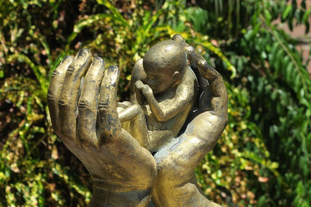 sculpture of an aborted baby in protective hands