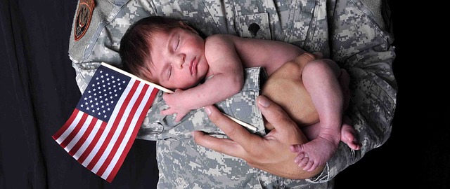 newborn with an american flag in the arms of an army man