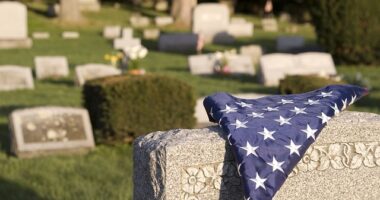 american flag folded on veteran tombstone